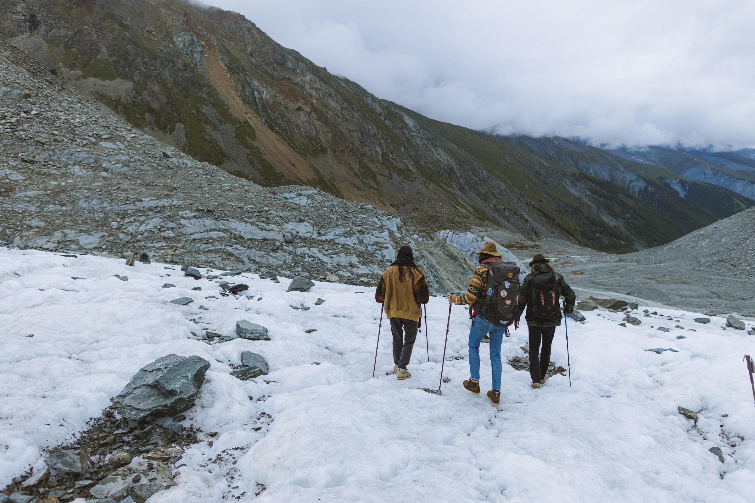 Three hikers traverse a snow-covered mountain in winter, showcasing adventure.