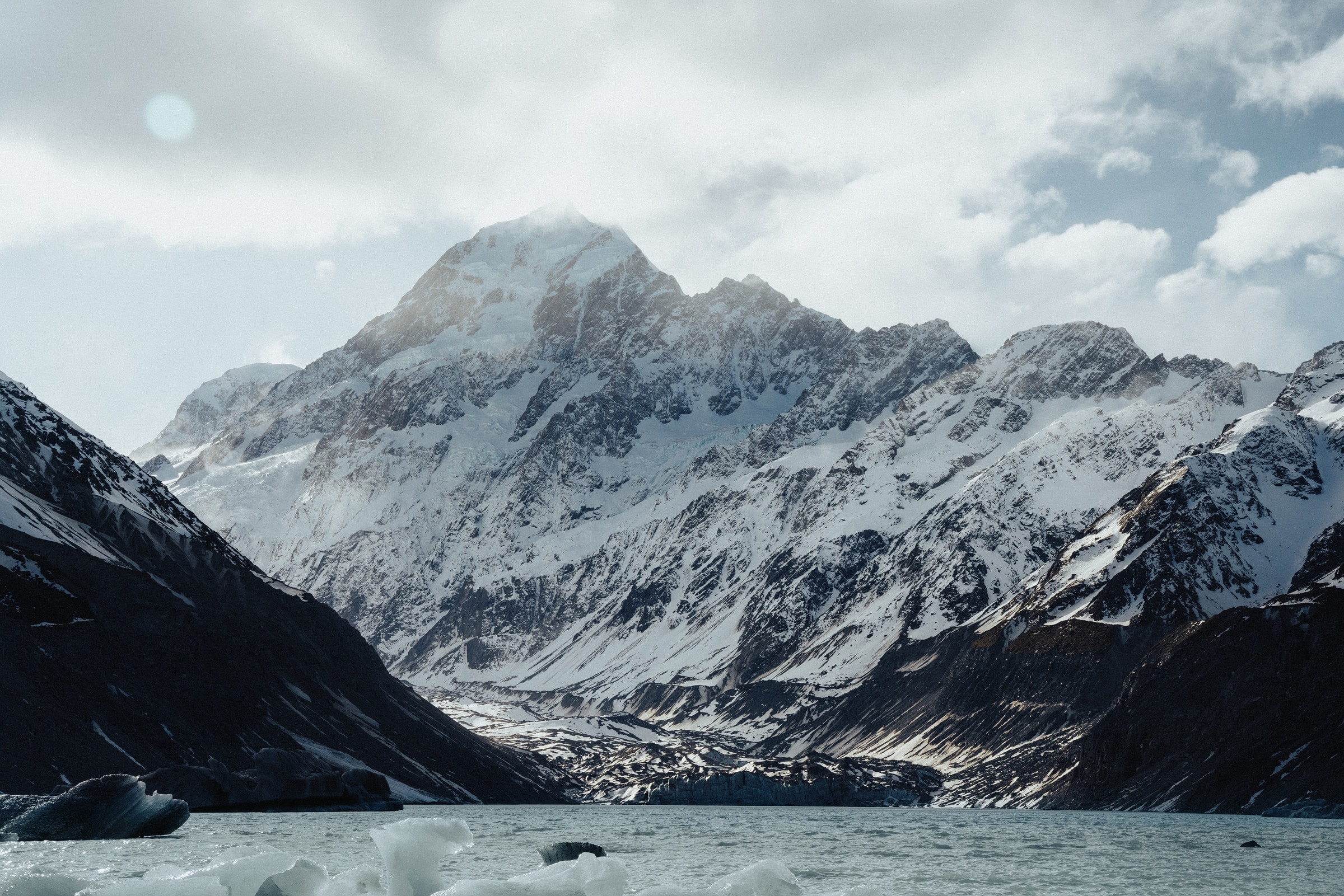 Stunning scenic view of the snow-capped Aoraki Mount Cook in New Zealand with icy waters.