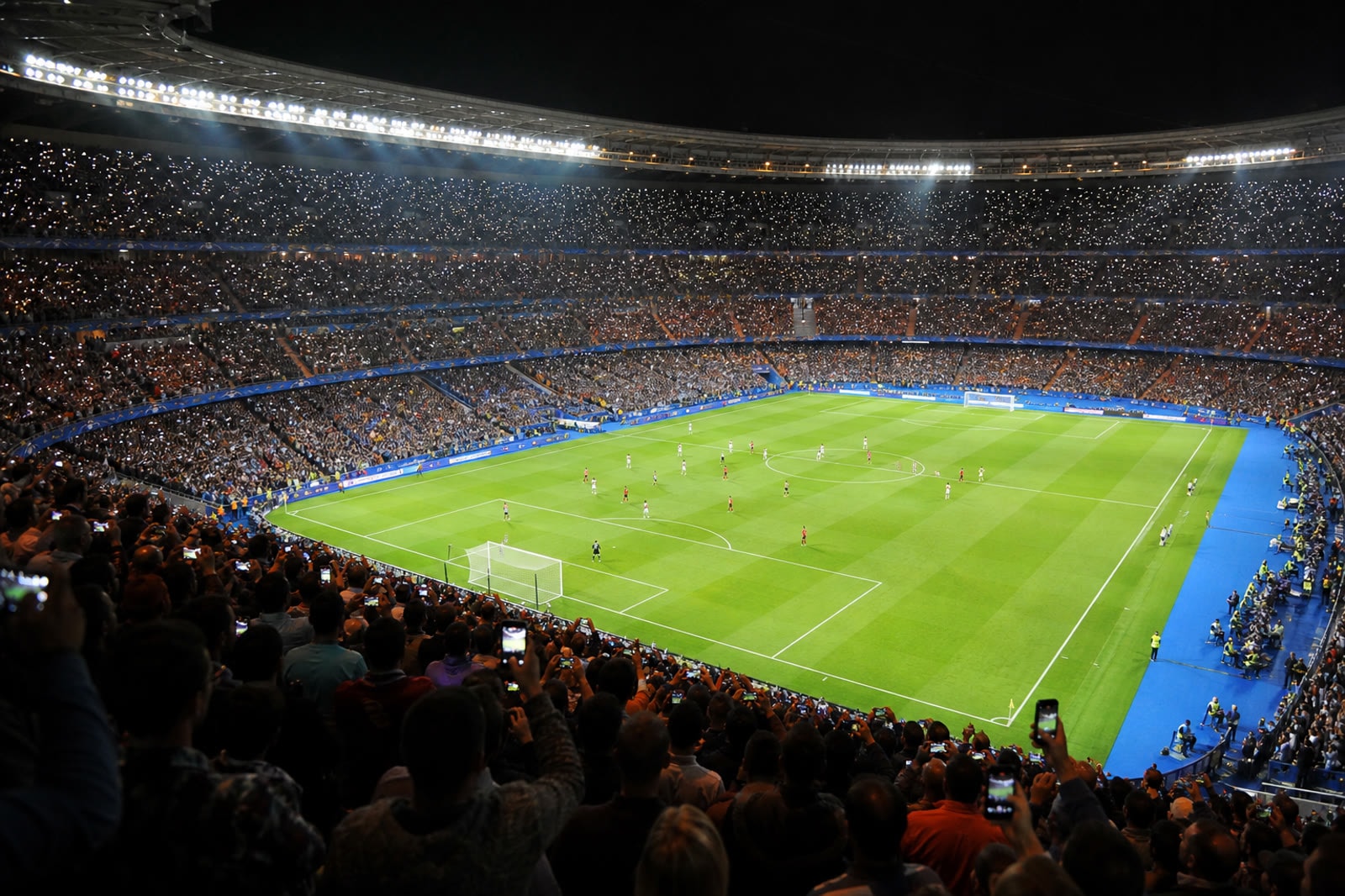 A packed stadium under floodlights during a championship final