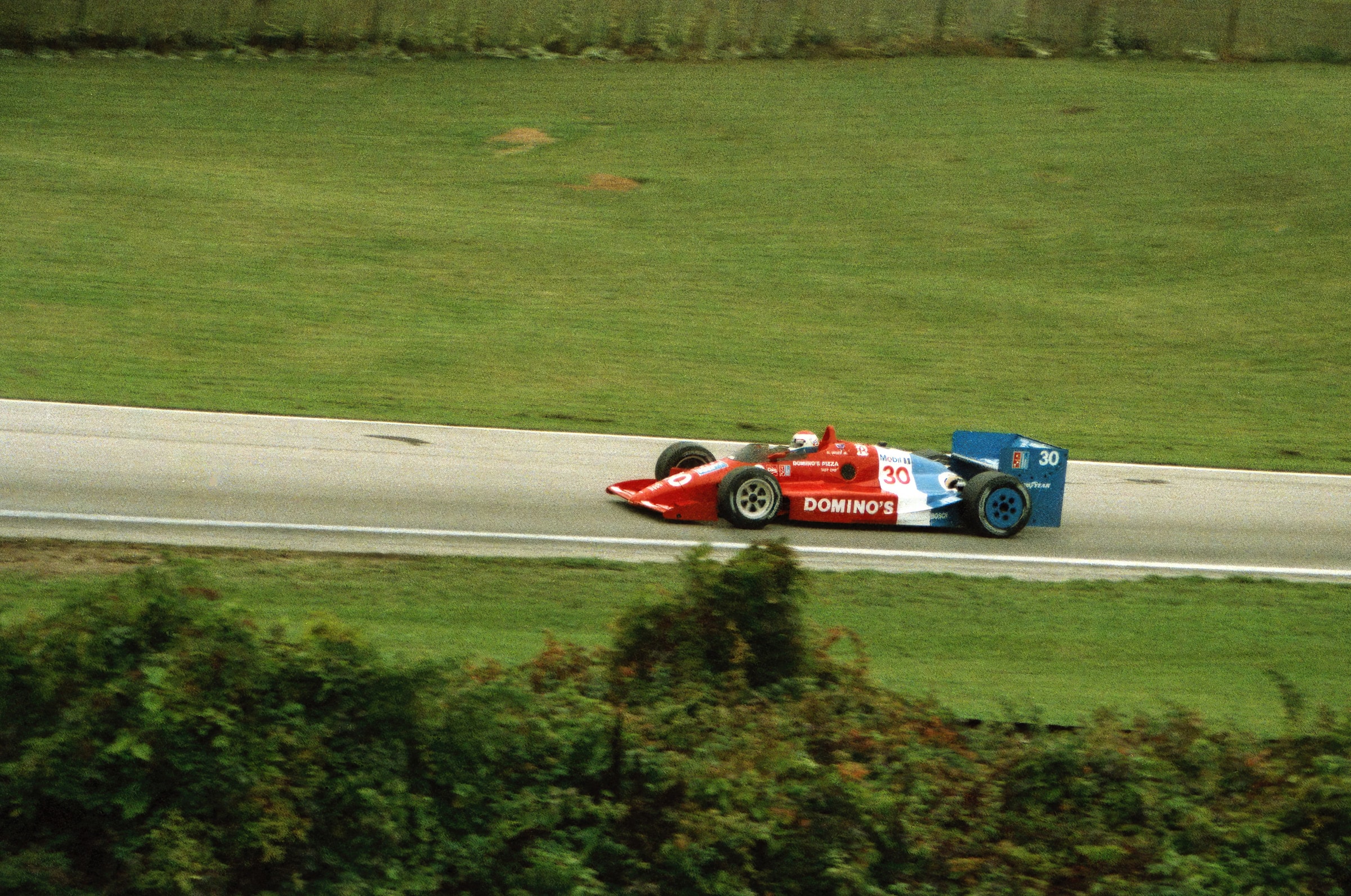 Race car speeding on the track at Elkhart Lake, Wisconsin. Captures the thrill of high-speed auto racing.